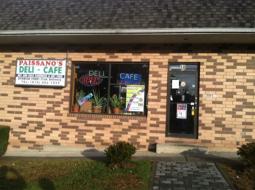 Paissano's Deli storefront: a white sign reading Paissano's Deli - Cafe on a brick front, with neon Deli, Cafe and Open signs in the window